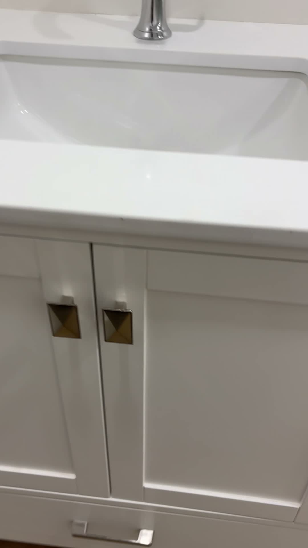 White shaker bathroom vanity with a quartz top and square brass pulls