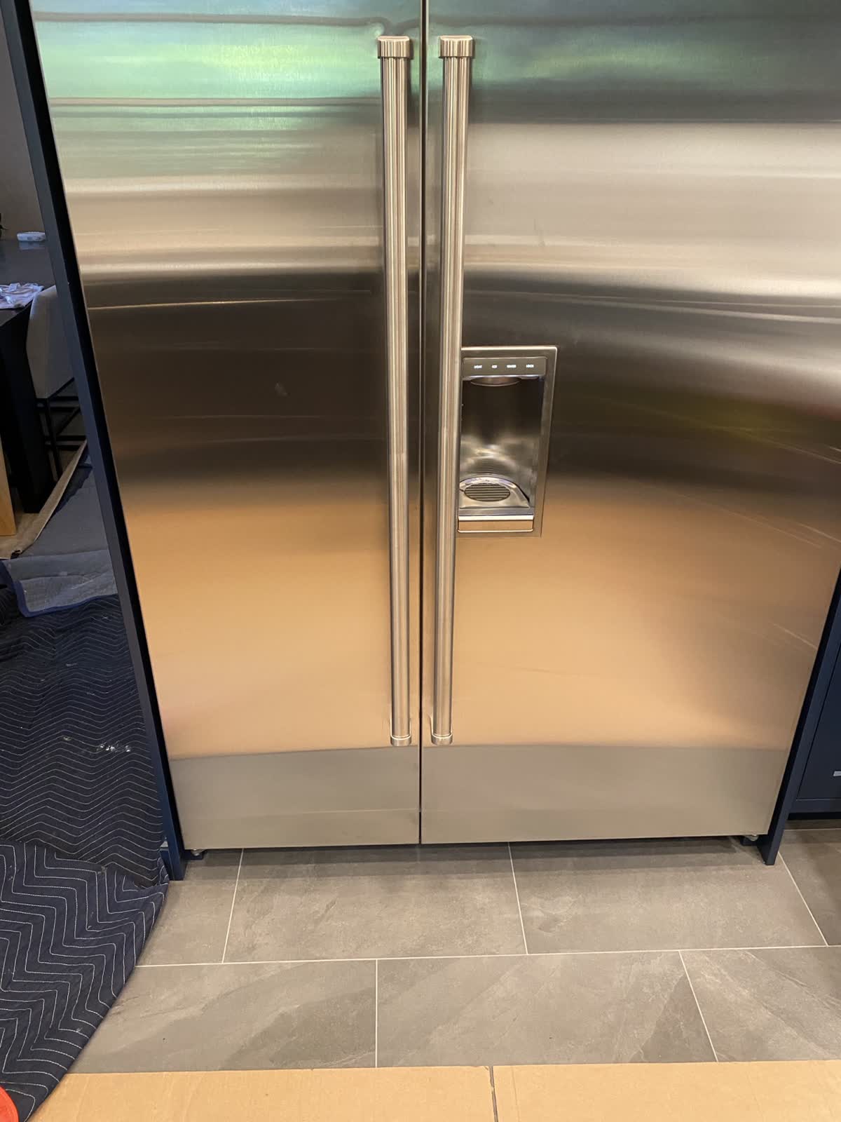 Large format porcelain tile floor running up to built-in stainless appliances