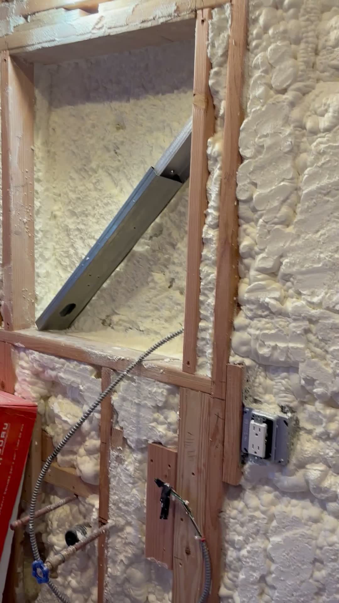 Exterior wall with spray foam insulation, new framing and an electrical box