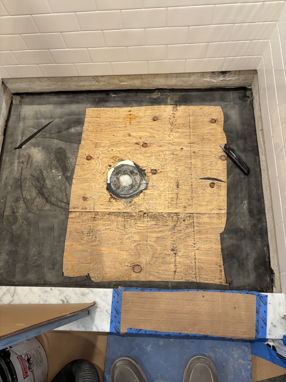 Shower floor stripped down to the waterproof liner around the drain